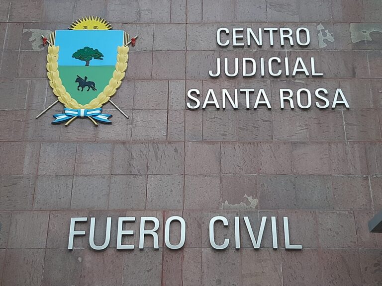 Ilustración de una balanza de la justicia sobre un fondo que representa la provincia de La Pampa