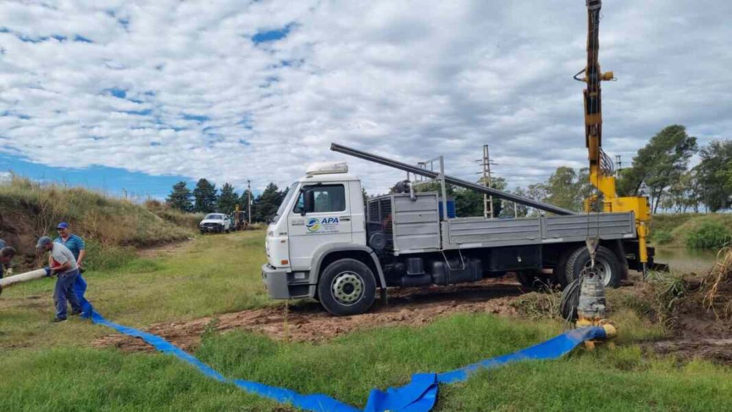 Operativo de maquinaria y personal técnico trabajando en una calle anegada de Santa Rosa, La Pampa.