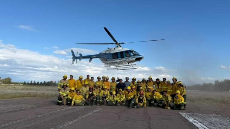 Personal de Defensa Civil y bomberos observando una aeronave durante la capacitación en medios aéreos para incendios